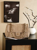 Side profile of Chanel AS5280 maxi flap bag in black suede, showing expanded accordion gusset and chain strap detail