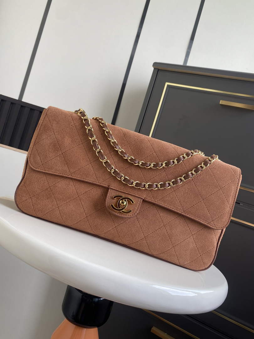 Chanel Maxi flap bag in dark beige suede featuring gold-tone chain strap and CC turn-lock closure, model AS6281.