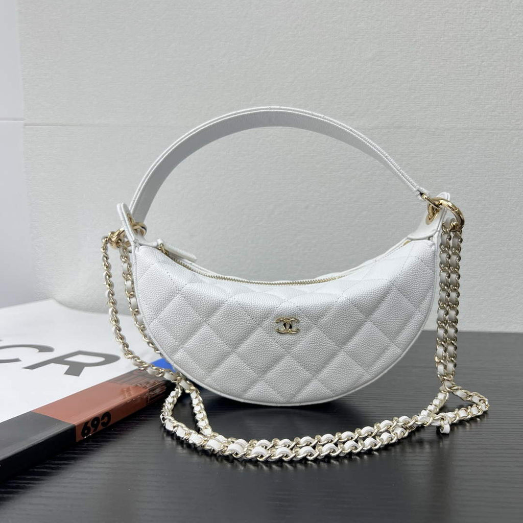 Close-up of gold tone chain strap on Chanel AP5094 clutch bag, woven leather shoulder pad detail