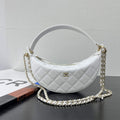 Close-up of gold tone chain strap on Chanel AP5094 clutch bag, woven leather shoulder pad detail