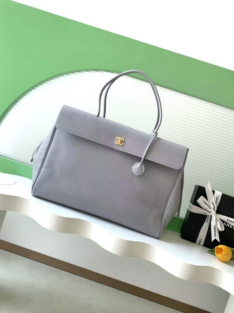 Close-up of Chanel AS6289 19 bag showing the large mixed-metal chain strap, flat diamond quilting, and Mademoiselle turn-lock closure.
