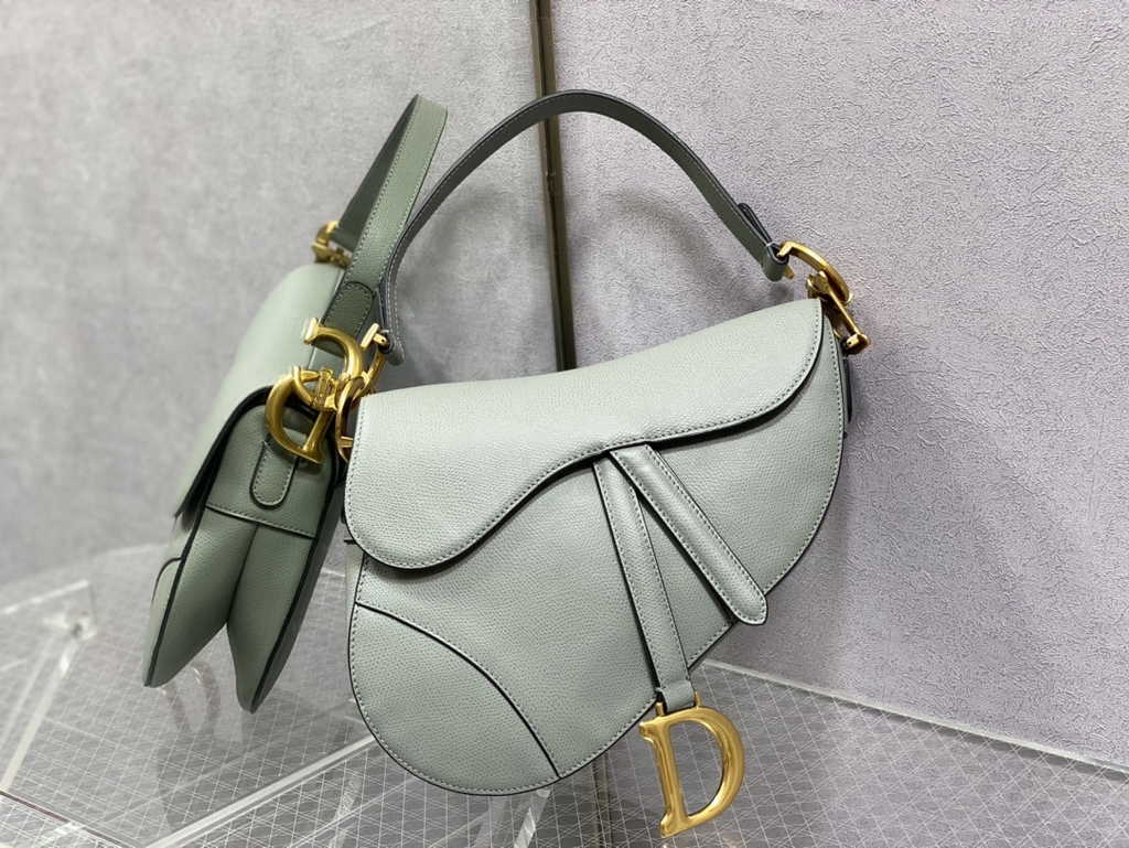 6. Dior Saddle Bag with strap styled with a beige trench coat and jeans