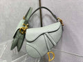 6. Dior Saddle Bag with strap styled with a beige trench coat and jeans