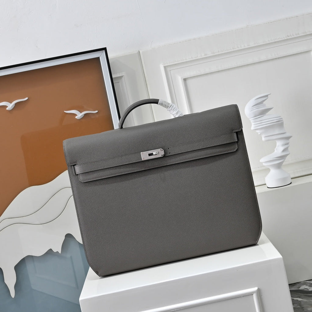 A person carrying Herm¨¨s Kelly D¨¦p¨ºche 36 Togo calfskin bag as a professional work briefcase